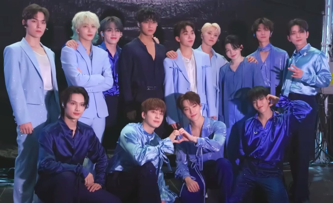 The thirteen members of SEVENTEEN posing together at their Caratland fan meeting in 2024